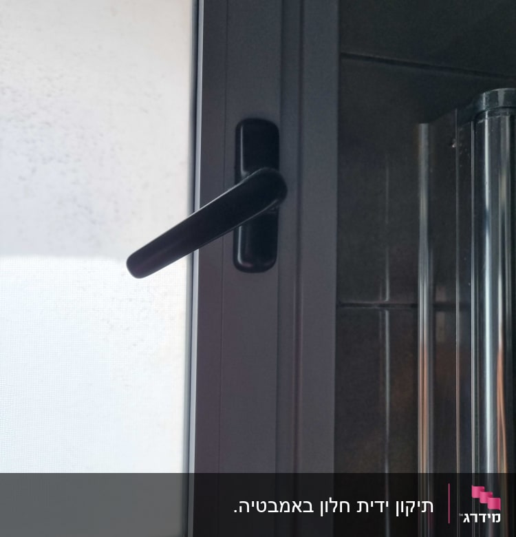 ידית תריס שחורה על חלון זכוכית